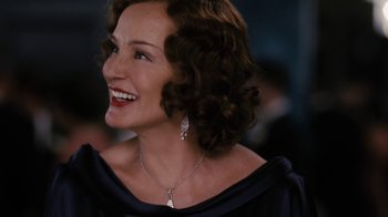 Movie still from “Grey Gardens” (2009), directed by Michael Sucsy – A person wearing a necklace and smiling; Close Up shot, Over the shoulder angle