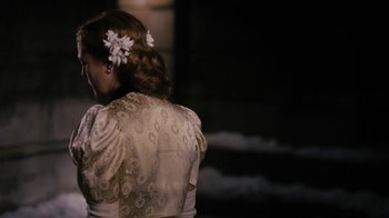 Movie still from “Grey Gardens” (2009), directed by Michael Sucsy – A woman in a white dress with flowers in her hair; Medium shot, Over the shoulder angle