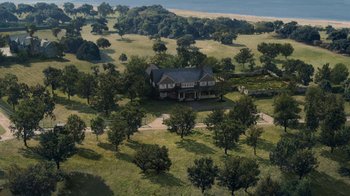 Movie still from “Grey Gardens” (2009), directed by Michael Sucsy – An aerial view of a house and some trees in a field; Extreme Wide shot, High angle
