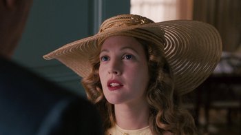 Movie still from “Grey Gardens” (2009), directed by Michael Sucsy – A woman wearing a straw hat and a yellow dress; Close Up shot, Over the shoulder angle