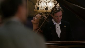 Movie still from “Grey Gardens” (2009), directed by Michael Sucsy – A man and a woman are playing a piano together; Medium shot, Over the shoulder angle