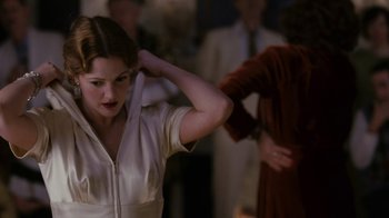 Movie still from “Grey Gardens” (2009), directed by Michael Sucsy – A woman in a white dress is holding her hair; Medium shot, Over the shoulder angle