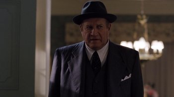 Movie still from “Grey Gardens” (2009), directed by Michael Sucsy – An older man wearing a suit and a hat; Medium shot, Over the shoulder angle