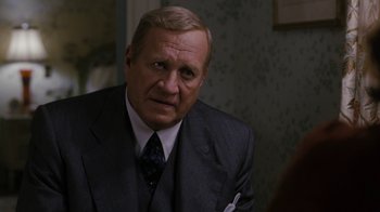 Movie still from “Grey Gardens” (2009), directed by Michael Sucsy – An older man wearing a suit and tie; Close Up shot, Over the shoulder angle