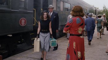 Movie still from “Grey Gardens” (2009), directed by Michael Sucsy – A group of people standing next to each other on a train platform; Medium shot, Over the shoulder angle