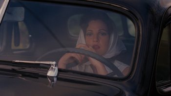 Movie still from “Grey Gardens” (2009), directed by Michael Sucsy – A woman sitting in the driver's seat of a car; Close Up shot, Over the shoulder angle