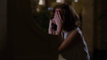 Movie still from “Grey Gardens” (2009), directed by Michael Sucsy – A woman covering her face with her hands; Medium shot, Over the shoulder angle