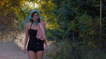 Movie still from “Grey Gardens” (2009), directed by Michael Sucsy – A woman walking down a dirt road wearing a black one piece; Medium shot, High angle