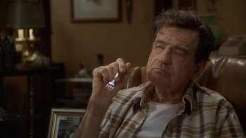 Movie still from “Grumpier Old Men” (1995), directed by Howard Deutch – An older man holding a cell phone in his hand; Close Up shot, High angle