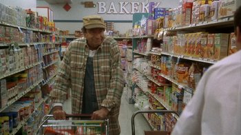 Movie still from “Grumpier Old Men” (1995), directed by Howard Deutch – An older man pushing a shopping cart in a grocery store; Medium shot, High angle