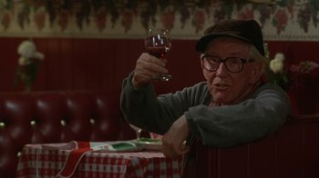 Movie still from “Grumpier Old Men” (1995), directed by Howard Deutch – An older man holding a glass of wine in his hand; Medium shot, Low angle