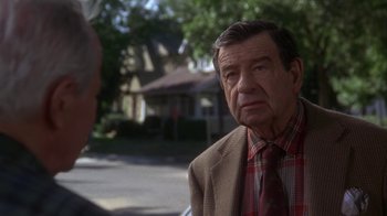 Movie still from “Grumpier Old Men” (1995), directed by Howard Deutch – An older man wearing a plaid shirt and a brown jacket; Close Up shot, Over the shoulder angle