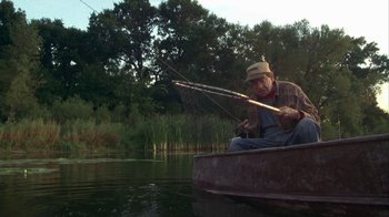 Movie still from “Grumpier Old Men” (1995), directed by Howard Deutch – An older man fishing in a boat on a lake; Wide shot, High angle