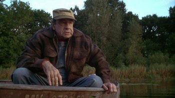 Movie still from “Grumpier Old Men” (1995), directed by Howard Deutch – An older man sitting on a boat in the water; Medium shot, High angle