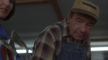 Movie still from “Grumpier Old Men” (1995), directed by Howard Deutch – An older man wearing a hat and overalls; Close Up shot, Over the shoulder angle