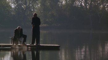 Movie still from “Grumpier Old Men” (1995), directed by Howard Deutch – A man standing on a raft in the middle of a lake; Wide shot, High angle