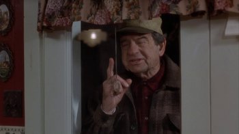 Movie still from “Grumpier Old Men” (1995), directed by Howard Deutch – An older man holding a stick in front of a mirror; Medium shot, High angle