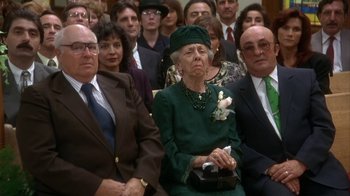 Movie still from “Grumpier Old Men” (1995), directed by Howard Deutch – An older woman in a green dress sitting in a crowd of people; Medium shot, High angle