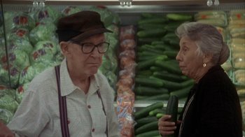 Movie still from “Grumpier Old Men” (1995), directed by Howard Deutch – An older man and woman are standing in front of a display of cucumbers; Medium shot, Over the shoulder angle