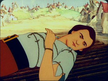 Movie still from “Gulliver's Travels” (1939), directed by William Henning – A woman chained to a wooden bench in front of a town; Medium shot, Low angle