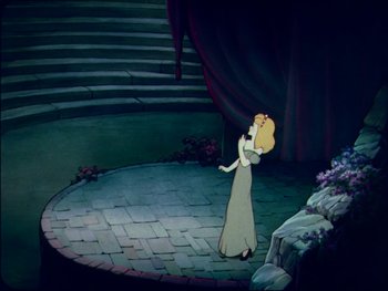 Movie still from “Gulliver's Travels” (1939), directed by William Henning – A woman in a white dress standing on a brick floor in front of a stage; Wide shot, High angle