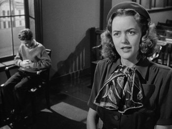 Movie still from “Gun Crazy” (1950), directed by Joseph H. Lewis – A woman in a hat standing in front of another woman; Medium shot, Over the shoulder angle