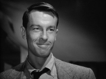 Movie still from “Gun Crazy” (1950), directed by Joseph H. Lewis – Black and white photograph of a man smiling; Close Up shot, Over the shoulder angle