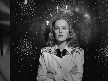 Movie still from “Gun Crazy” (1950), directed by Joseph H. Lewis – A young woman standing in front of a wall; Medium shot, Low angle