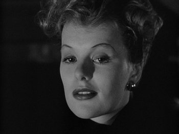 Movie still from “Gun Crazy” (1950), directed by Joseph H. Lewis – An old photo of a woman in a black dress; Close Up shot, Low angle