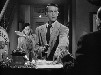 Movie still from “Gun Crazy” (1950), directed by Joseph H. Lewis – A man and a woman are standing in front of a table; Medium shot, Low angle