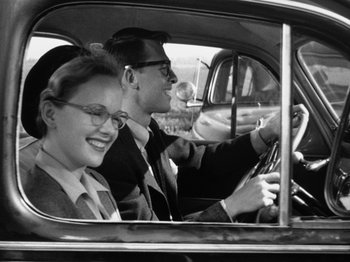 Movie still from “Gun Crazy” (1950), directed by Joseph H. Lewis – A man and a woman sitting in the drivers seat of a car; Medium shot, Low angle