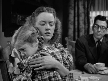 Movie still from “Gun Crazy” (1950), directed by Joseph H. Lewis – A woman holding a young girl in her arms; Medium shot, Over the shoulder angle