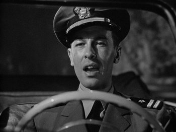 Movie still from “Gun Crazy” (1950), directed by Joseph H. Lewis – A man in a uniform driving a car; Close Up shot, Low angle