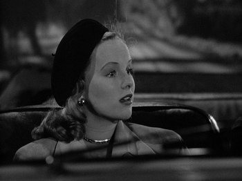 Movie still from “Gun Crazy” (1950), directed by Joseph H. Lewis – A woman in a hat sitting in the back of a car; Close Up shot, Low angle