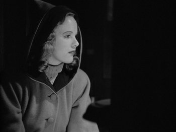 Movie still from “Gun Crazy” (1950), directed by Joseph H. Lewis – A black and white photo of a woman wearing a hooded jacket; Close Up shot, Over the shoulder angle