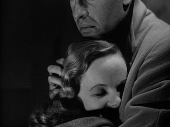Movie still from “Gun Crazy” (1950), directed by Joseph H. Lewis – A man holding a woman's head while she looks at him; Close Up shot, Low angle