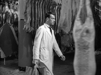 Movie still from “Gun Crazy” (1950), directed by Joseph H. Lewis – A man in a lab coat walking in front of a bunch of animals; Medium shot, High angle