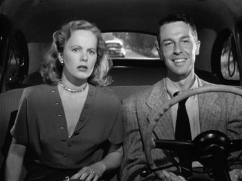 Movie still from “Gun Crazy” (1950), directed by Joseph H. Lewis – A man and a woman sitting in the back of a car; Medium shot, Low angle