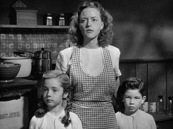 Movie still from “Gun Crazy” (1950), directed by Joseph H. Lewis – A woman and two young children standing in a kitchen; Medium shot, Low angle