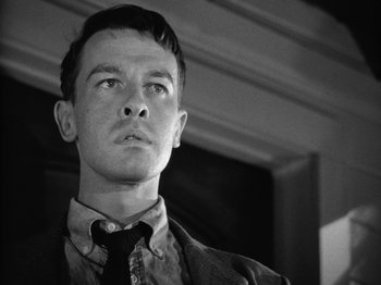 Movie still from “Gun Crazy” (1950), directed by Joseph H. Lewis – Black and white photograph of a young man wearing a neck tie; Close Up shot, Low angle