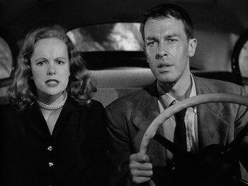 Movie still from “Gun Crazy” (1950), directed by Joseph H. Lewis – A man and a woman sitting in the back of a car; Close Up shot, Low angle