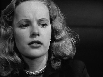 Movie still from “Gun Crazy” (1950), directed by Joseph H. Lewis – A black and white photo of a woman with a pearl necklace; Close Up shot, Low angle