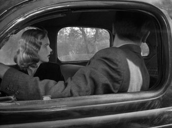 Movie still from “Gun Crazy” (1950), directed by Joseph H. Lewis – A man and a woman sitting in the back of a car; Medium shot, Low angle
