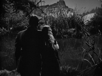Movie still from “Gun Crazy” (1950), directed by Joseph H. Lewis – A man and a woman walking near a body of water; Wide shot, High angle