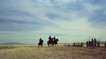 Movie still from “Gunfight at the O.K. Corral” (1957), directed by John Sturges – A group of men riding horses across a field; Extreme Wide shot, Low angle