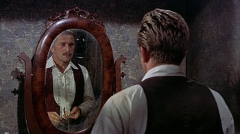 Movie still from “Gunfight at the O.K. Corral” (1957), directed by John Sturges – A man looking at himself in the mirror; Medium shot, Over the shoulder angle