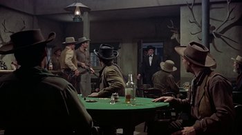 Movie still from “Gunfight at the O.K. Corral” (1957), directed by John Sturges – A group of men sitting around a green table; Wide shot, Over the shoulder angle