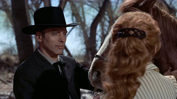 Movie still from “Gunfight at the O.K. Corral” (1957), directed by John Sturges – A man in a hat and a suit and a horse; Close Up shot, Over the shoulder angle