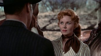 Movie still from “Gunfight at the O.K. Corral” (1957), directed by John Sturges – A woman in a striped shirt is talking to a man in a suit; Close Up shot, Over the shoulder angle
