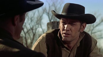 Movie still from “Gunfight at the O.K. Corral” (1957), directed by John Sturges – A man wearing a cowboy hat talking to another man in front of a tree; Close Up shot, Over the shoulder angle